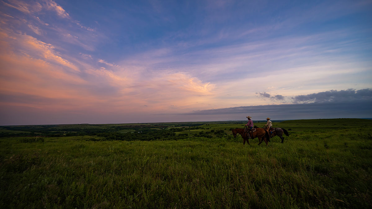 ranchers riding horses in kansas