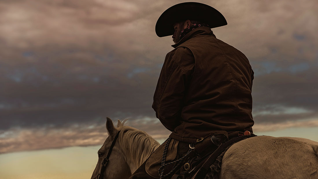 Cowboy on top of horse kansas sunrise